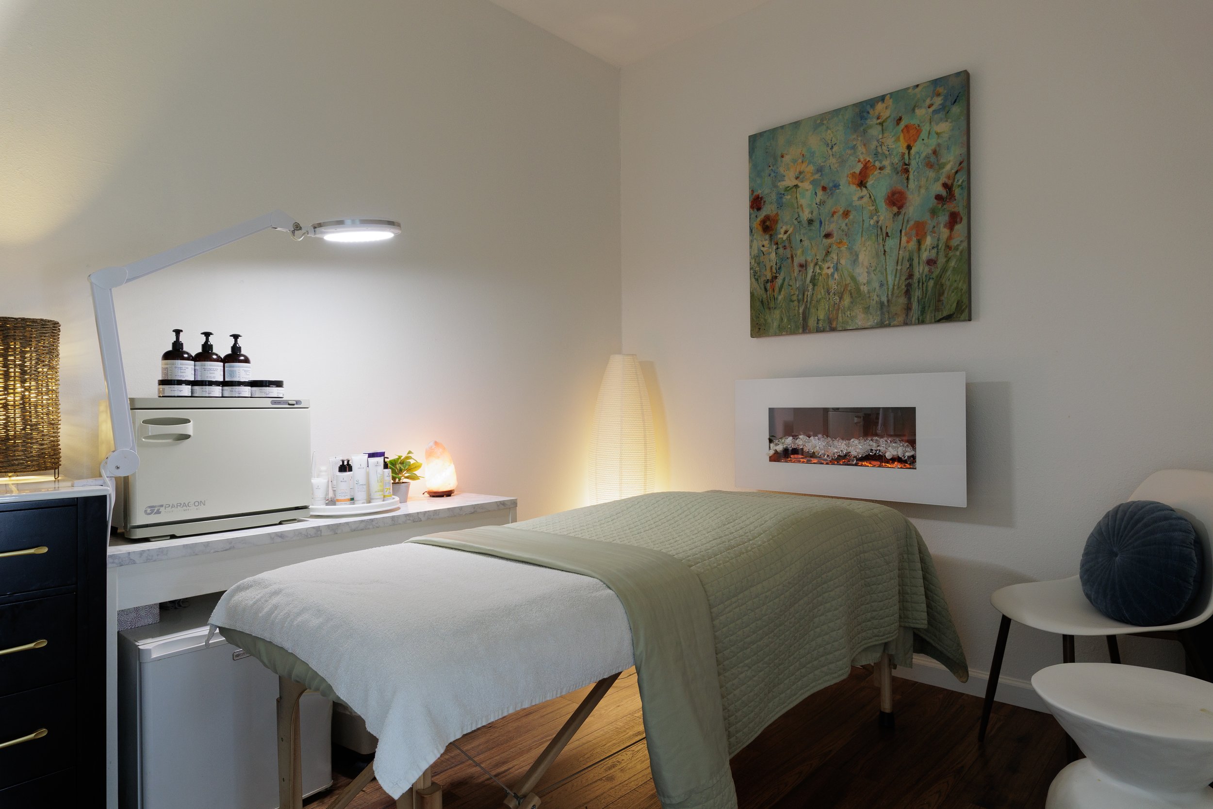 Mint & Thyme treatment room with massage table and fireplace